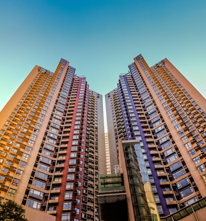 home-hero Tall, colorful skyscrapers reaching into the blue sky in Hong Kong, showcasing modern architecture.