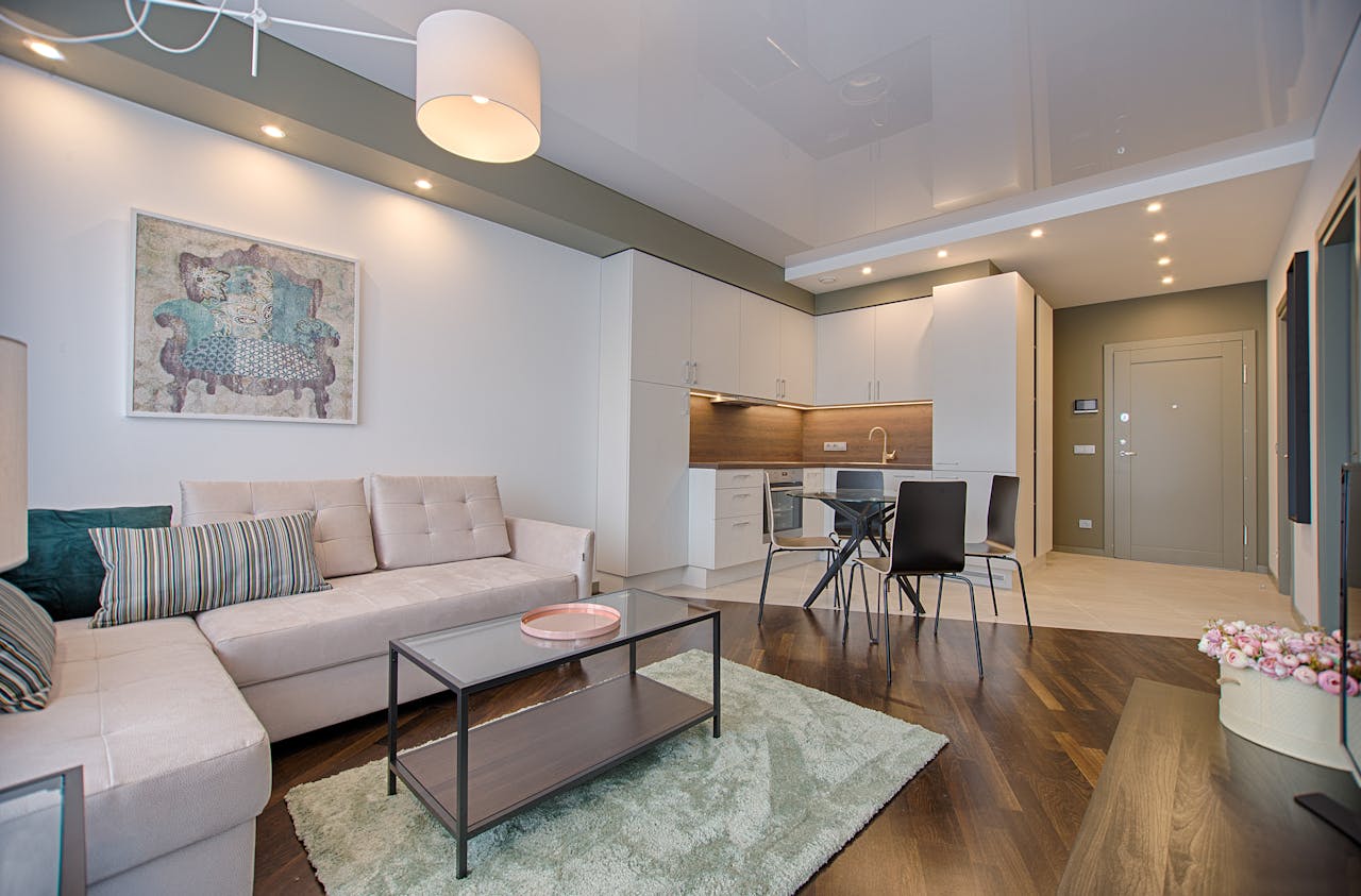 services-05 Spacious modern living room featuring chic furniture, stylish decor, and a minimalist kitchen.